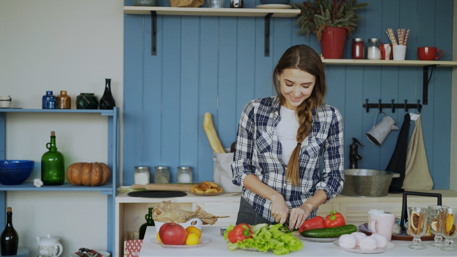 A woman is chopping vegetables in a kitchen